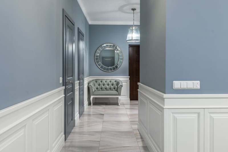 Corridor with steel blue walls above white wall panelling