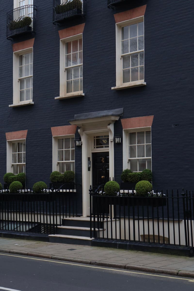 Terraced house painted black with crisp white window frames and door