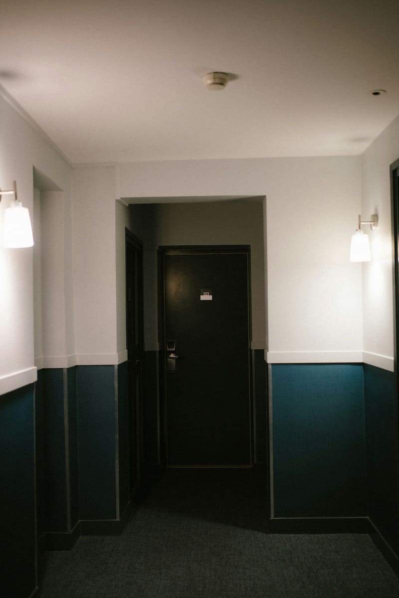 Corridor painted two-tone: dark teal below, white above