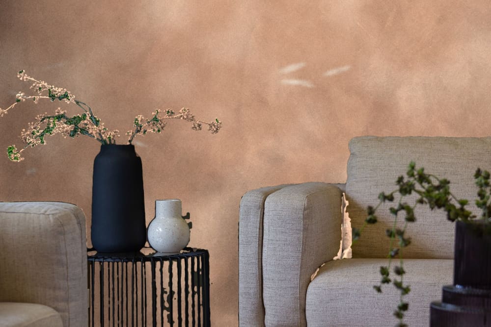 Demonstration: a living room wall in bare pink plaster with filler patches, before painting