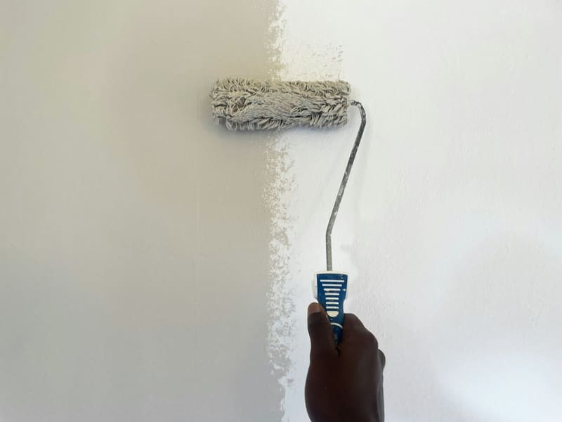 Roller laying a fresh coat of white paint with a crisp wet edge