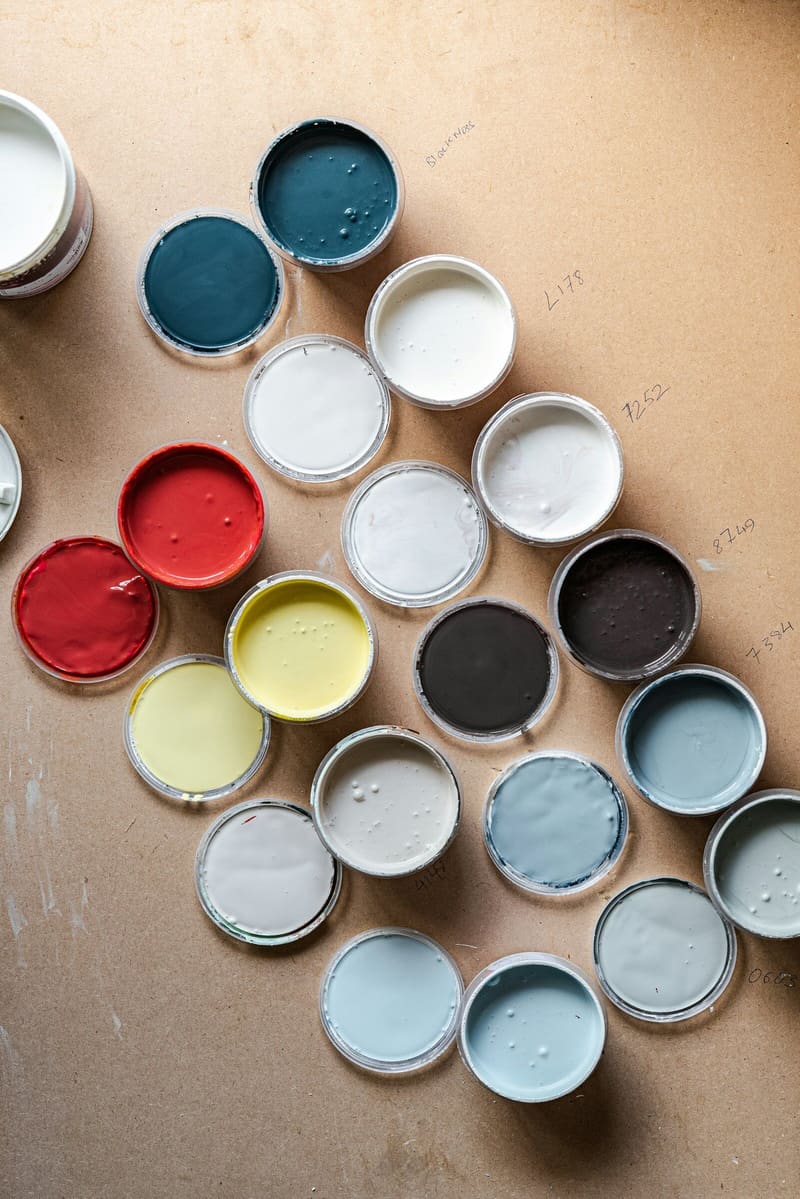 Paint tin lids from above in navy, white, grey and red