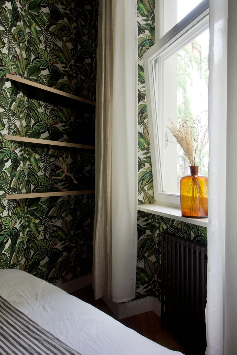 Botanical leaf wallpaper around a white window